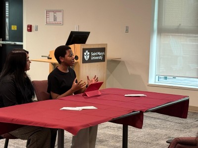 Honours candidates Rozana Rashid, Charis Gervais sitting at a table